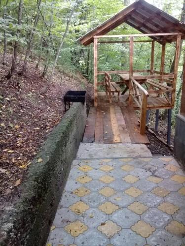 a pavilion with a picnic table and a bench at Tranquille Dilijan in Dilijan