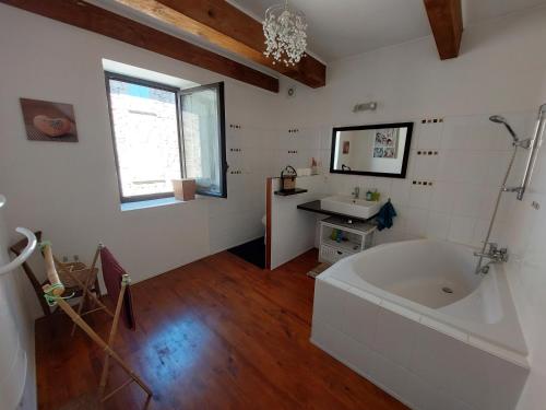 baño con bañera grande y lavamanos en Maison de Sao en pierres, en Lablachère