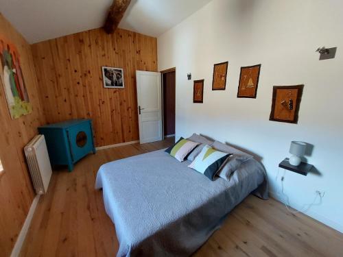 1 dormitorio con 1 cama en una habitación con paredes de madera en Maison de Sao en pierres, en Lablachère
