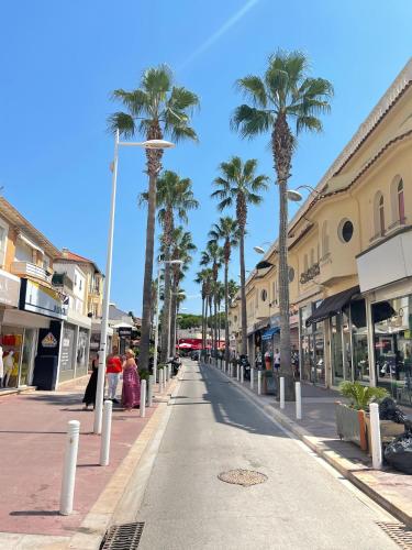 a city street with palm trees and buildings at Centre de Juan les pins 100m plages Easy Check-in in Juan-les-Pins