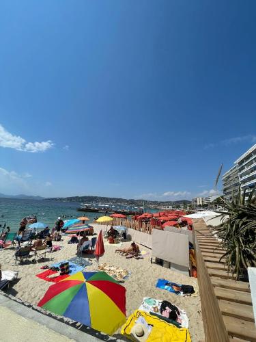 a beach with umbrellas and people laying on the sand at Centre de Juan les pins 100m plages Easy Check-in in Juan-les-Pins