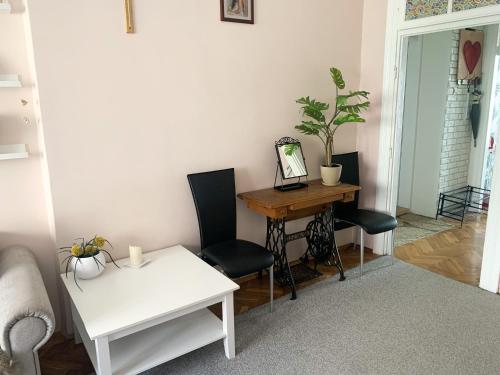 een woonkamer met een tafel en stoelen en een bureau bij Apartament przy Dworcu in Radom