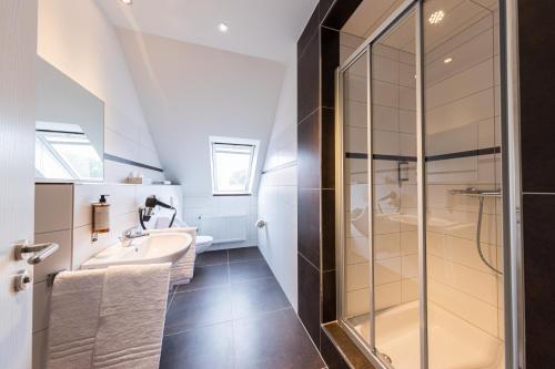 een badkamer met een wastafel en een douche bij Pension Sonne Appartements in Minden