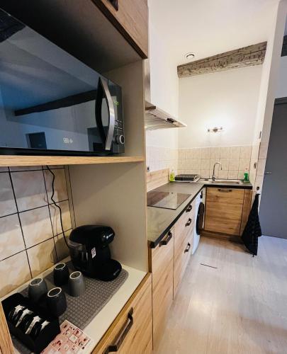 une petite cuisine avec un évier et un micro-ondes dans l'établissement Appartement T2 dans le centre ville de Carcassonne, à Carcassonne