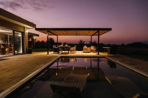 a patio with a table and chairs next to a pool at Tandweni Villa in Pongola Game Reserve