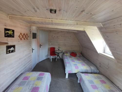 a room with two beds and a table in a cabin at Wspaniały Zakątek in Sędziszowa