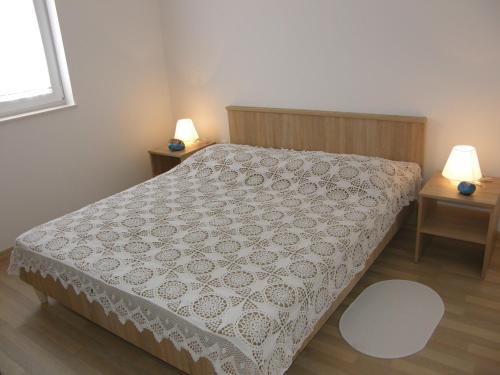 - une chambre avec un lit et 2 tables avec des lampes dans l'établissement Apartment Pavlakovic, à Baška