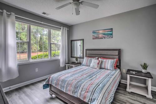 Un dormitorio con una cama y dos ventanas. en Pool and Golf Course Access North Myrtle Beach Gem, en North Myrtle Beach