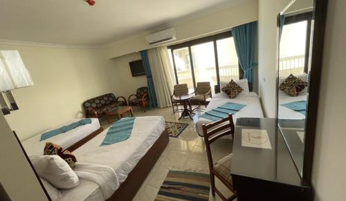 a hotel room with two beds and a living room at Delmar Hotel Matrouh in Marsa Matruh