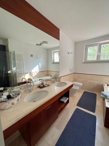 baño con 2 lavabos y espejo grande en MyVilla B&B, en Palazzo Canavese