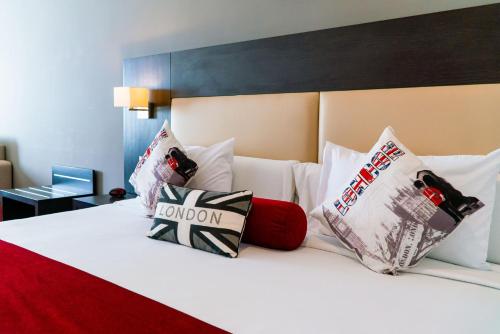 a large white bed with pillows on top of it at Hôtel Tamuda Beach in M'diq