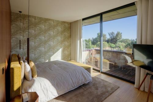 um quarto com uma cama e uma grande janela em Troya Regal Villa by CadenzaLux em Tróia