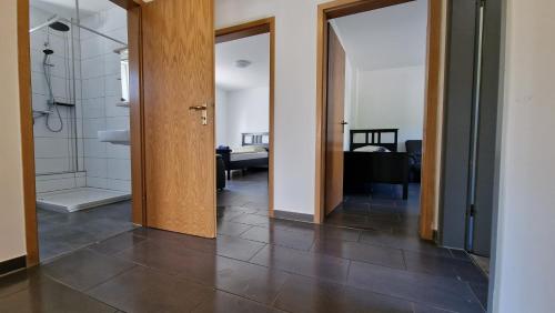 a hallway with two doors and a bathroom with a shower at Apartments Overath in Overath