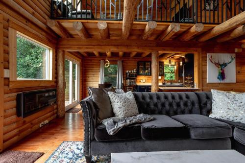 a living room with a black couch in a cabin at Mountain View Sanctuary in Weaverville
