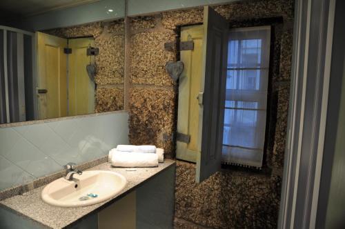 a bathroom with a sink and a mirror at Casa do Meio da Vila in Loriga