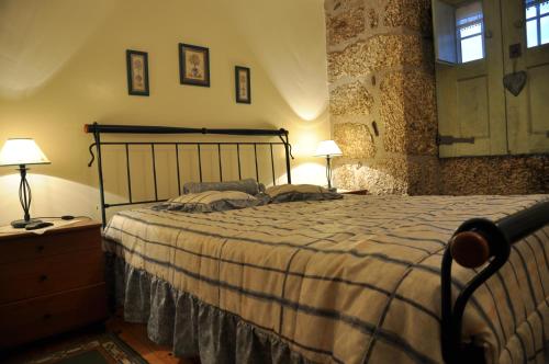 a bedroom with a bed and two lamps and a window at Casa do Meio da Vila in Loriga