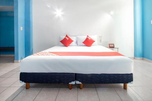 1 dormitorio con 1 cama grande con almohadas rojas en OYO Hotel Estacion,José Cardel,Parque Central Revolución en José Cardel