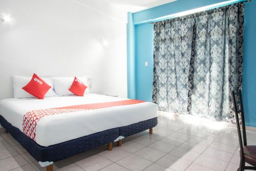 Un dormitorio con una cama con almohadas rojas y una ventana en OYO Hotel Estacion,José Cardel,Parque Central Revolución, en José Cardel