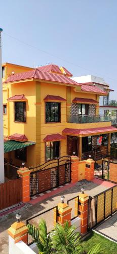 a yellow building with a fence in front of it at Diamond Cottage in Alibaug
