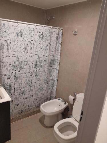 a bathroom with a toilet and a shower curtain at París 1 Monoambiente in Rosario