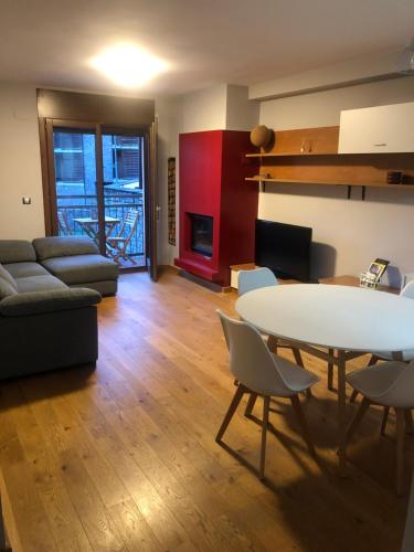 uma sala de estar com uma mesa e um sofá em Precioso apartamento con piscina, ideal familias! em Sort