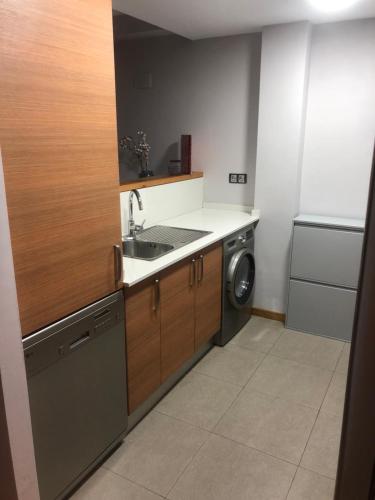 a kitchen with a sink and a washing machine at Precioso apartamento con piscina, ideal familias! in Sort