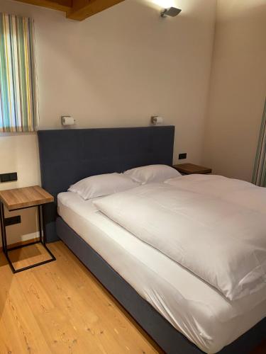 a bedroom with a large white bed and a table at ClubHotel Hinterthal Am FlorySee 12 in Hinterthal