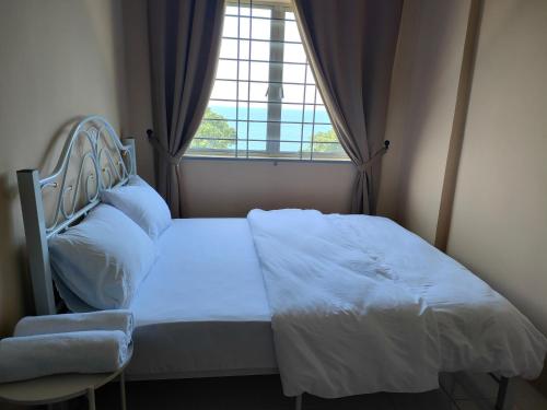 een bed in een kamer met een groot raam bij Sutra Damai Seaview in Kuantan