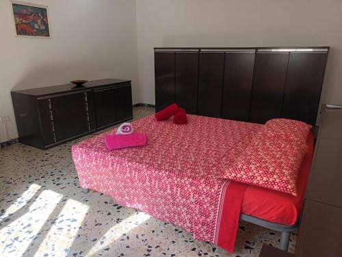 una camera da letto con un grande letto con una coperta rosa di Casa Bellini Oristano a Oristano