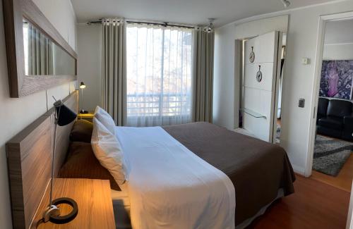 Habitación de hotel con cama y ventana en Brizen Apartments, en Santiago