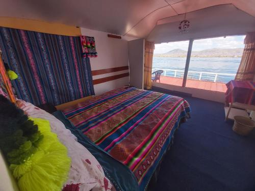 a bedroom with a bed with a view of the ocean at Titicaca Utama Lodge Perú in Puno