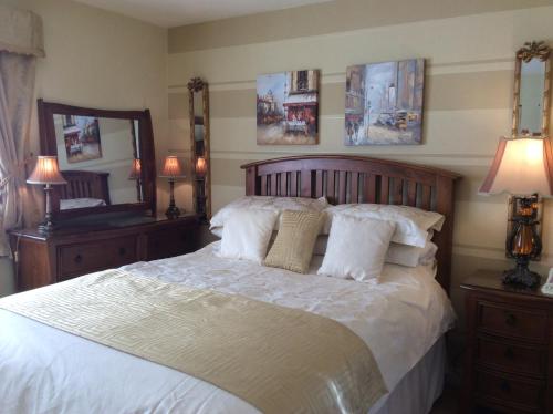 sypialnia z dużym łóżkiem z białą pościelą i poduszkami w obiekcie Lurgan West Lodge w mieście Randalstown