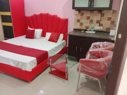 um quarto com uma cama vermelha e uma cadeira em City Palace em Panchkula