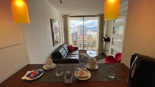 un soggiorno con tavolo da pranzo e vista sulla città di Brizen Apartments - Manuel Montt a Santiago