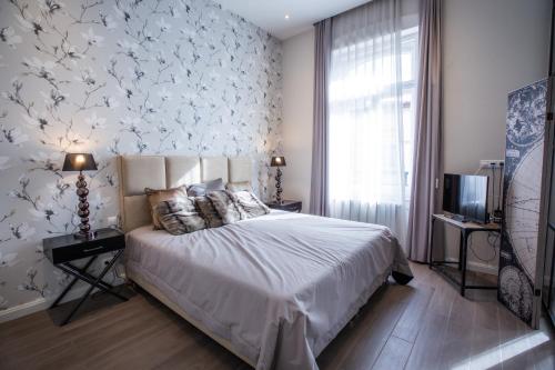 1 dormitorio con 1 cama y una pared con flores en 205m2 Penthouse with 75m2 Castle View Terrace and Barbercue - My Loft in Budapest en Budapest