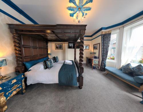 een slaapkamer met een groot hemelbed en een bank bij Allerdale Guest House in Keswick