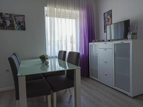 a dining room table with chairs and a television in a room at Casa Lauda in Bad Vöslau in Bad Vöslau