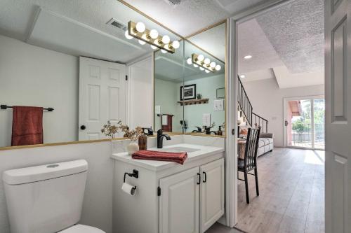 a bathroom with a toilet and a sink and a mirror at Sunny St George Condo with Mtn-View Balcony! in St. George