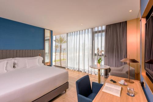 Habitación de hotel con cama, mesa y escritorio. en Barceló Tanger en Tánger