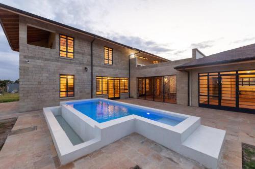 a swimming pool in front of a house at The Landing Nanyuki - One Bedroom Guest house in Nanyuki