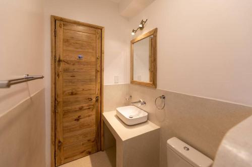 a bathroom with a sink and a toilet and a mirror at The Landing Nanyuki - One Bedroom Guest house in Nanyuki