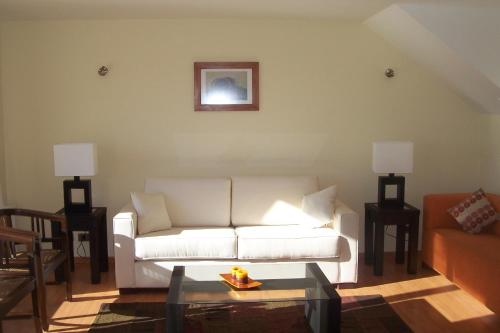 a living room with a white couch and a table at Apart Hotel Sol y Lago in Pucón