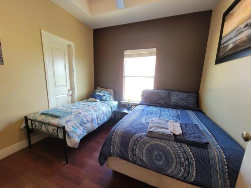 1 Schlafzimmer mit 2 Betten und einem Fenster in der Unterkunft Modern, Private, Smart 4 BR Condo in Desirable Location in McAllen with Pool! in McAllen