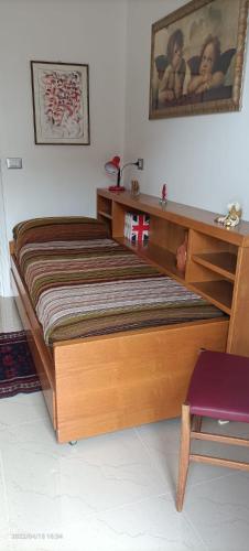 a wooden bed with a desk and a purple chair at Appartamento “Young” in Paderno Dugnano