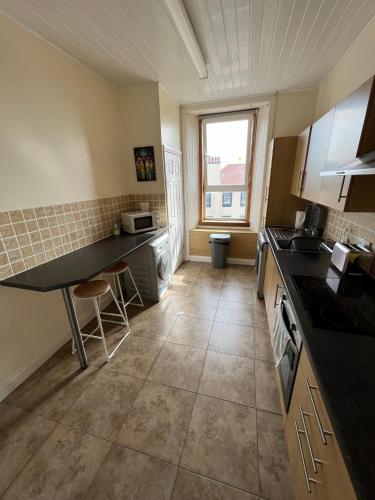 a kitchen with a sink and a counter top at Dalblair Apartment in Ayr