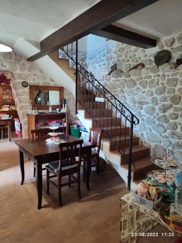 a dining room with a table and a stone wall at B&B Casal Cominium in San Donato Val di Comino