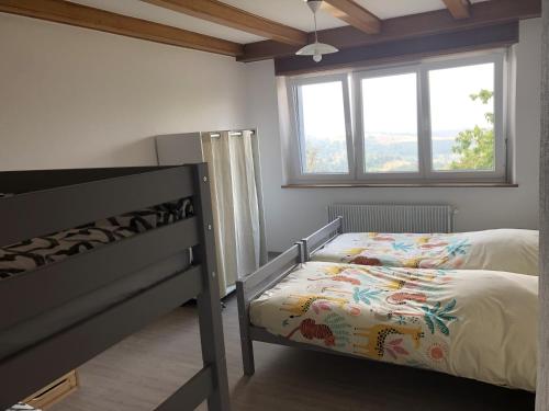 - une chambre avec des lits superposés et une fenêtre dans l'établissement gîte de montagne au pied du Champ du Feu (Alsace), à Belmont