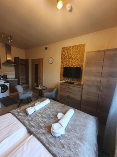 um quarto com uma cama grande e 2 toalhas em Harmony apartments em Mórahalom