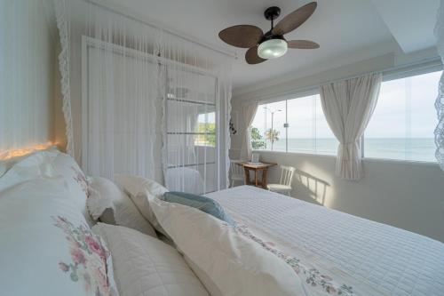 a white bedroom with a bed and a window at Pousada Recanto da Família in Natal