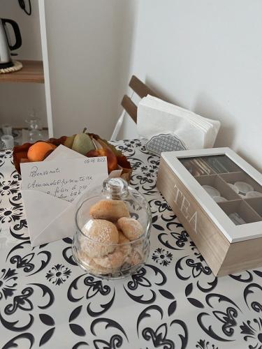 Acasadelpescatore Bed and Breakfast في سان بنيديتّو ديل ترونتو: طاولة عليها وعاء زجاجي من البسكويت وعلبة